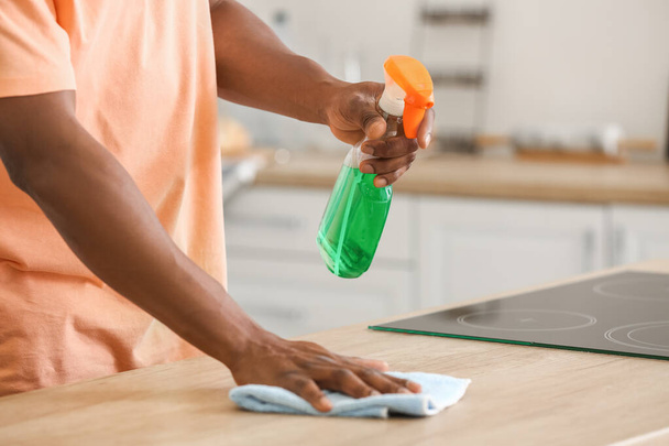 Hombre afroamericano limpiando su cocina - Foto, imagen