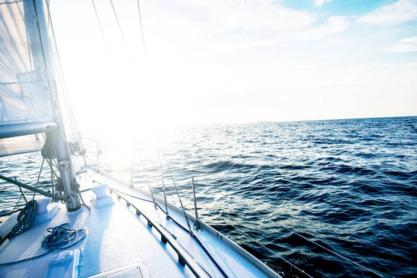 Plavím se při západu slunce. Pohled z paluby jachty na příď a plachty. Baltské moře, Lotyšsko - Fotografie, Obrázek