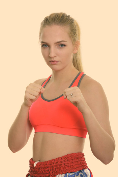 Studio shot of young beautiful teenage girl muay thai fighter ready to fight - Foto, afbeelding