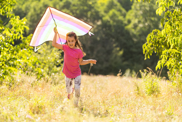 little girl running outdoor with a kite - 写真・画像