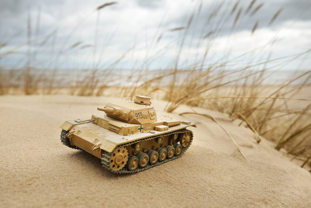 Modèle allemand Panzer III de la Seconde Guerre mondiale jouet réservoir close-up. Dunes de sable de la mer Baltique en arrière-plan. Modélisation, collecte, éducation, concepts d'histoire - Photo, image