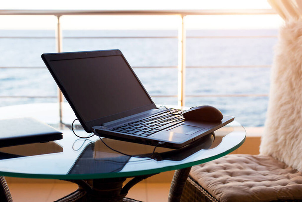 Laptop on the table on the hotel balcony with sea view. Remote work, doing business on vacation. Fast Internet, communication on weekends. Always in touch. Copy space. Mock up - Valokuva, kuva