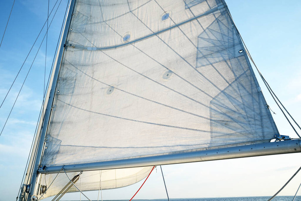 Sloop rigged yacht sailing in an open Baltic sea on a clear day. Close-up view from the deck to the bow, mast and sails. Latvia - Photo, Image