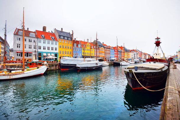 デンマークのコペンハーゲンにあるニャーハン(新港)のパノラマビュー。カラフルな伝統的な家。運河に停泊する帆船。ウイルス(COVID-19)の発生、隔離、ロックダウンのために誰もいません - 写真・画像