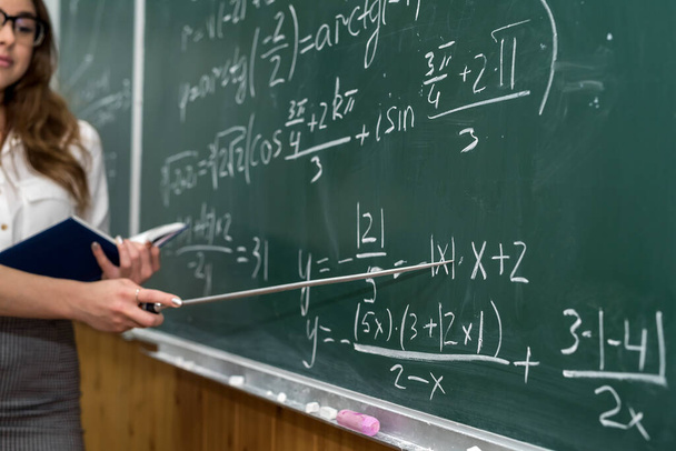 A professora escreveu fórmulas matemáticas no quadro negro e explicou uma lição. Escola - Foto, Imagem