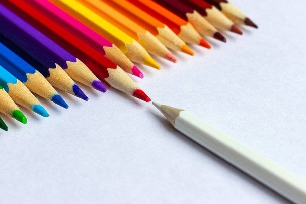Os lápis brancos e vermelhos opõem-se um ao outro. Muitos lápis coloridos em uma fileira. - Foto, Imagem