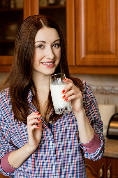 Дівчина зі склянкою молока на кухні вранці
 - Фото, зображення