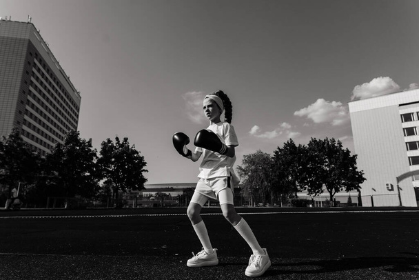 Female child boxer in gloves, feminism concept. Back to school, physical training. - Photo, Image