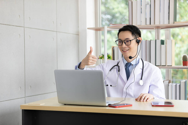 aasialainen lääkäri puhuu potilaan tai työtoverin kanssa online-videokeskustelun kautta tietokoneen kanssa sairaalassa - Valokuva, kuva