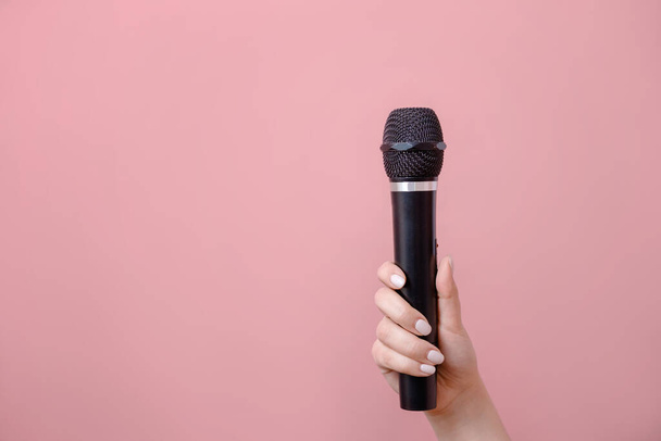 microphone in female hand on pink background - Fotó, kép