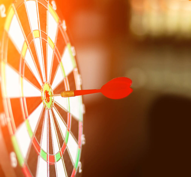 dart board heeft dart pijl gooien raken van het centrum van een schietschijf voor zakelijke targeting en winnende doelen zakelijke concepten. - Foto, afbeelding