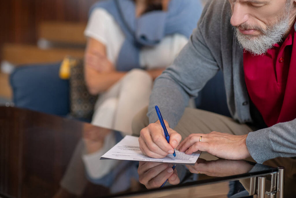 Bearded man writing a petition for divorce - Fotoğraf, Görsel