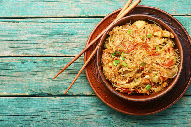 Funchoza,chinese noodles with spices and chicken meat on wooden table - Foto, afbeelding