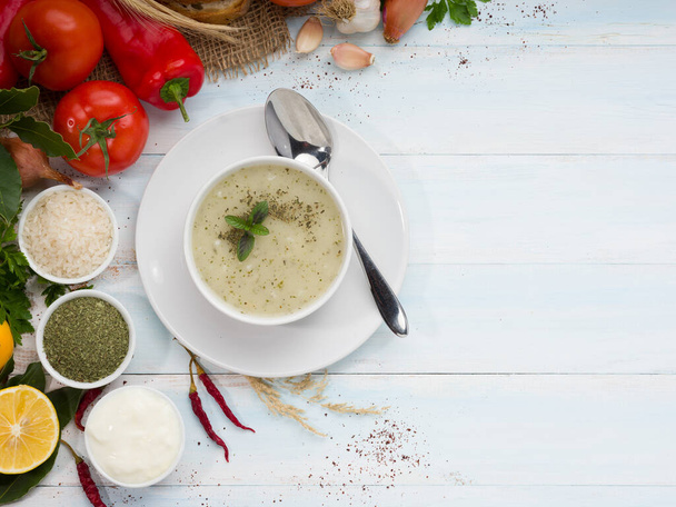Яйла Суп (турецкий; "Йогуртовый суп") с красочными овощами на белом столе. Суп традиционной турецкой кухни. - Фото, изображение