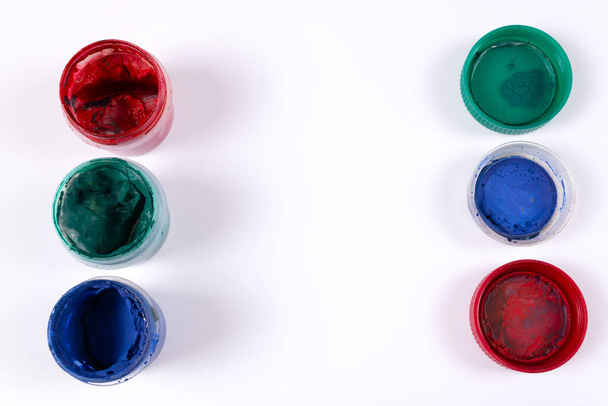 Tre vasetti aperti di guazzo rosso, verde, blu e loro coperchi verdi, blu, rossi invertiti - Foto, immagini