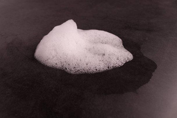 біла піна на темній поверхні вид збоку
 - Фото, зображення