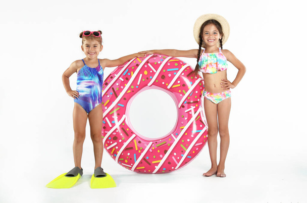 Cute little children in beachwear with bright inflatable ring on white background - Φωτογραφία, εικόνα