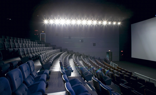 Cinema interior with lights on. Chairs and screen. - Photo, Image