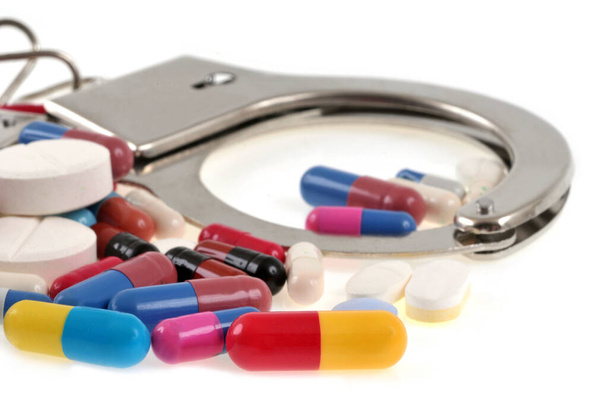 Conceito de tráfico de drogas com algemas e narcóticos close-up em fundo branco - Foto, Imagem