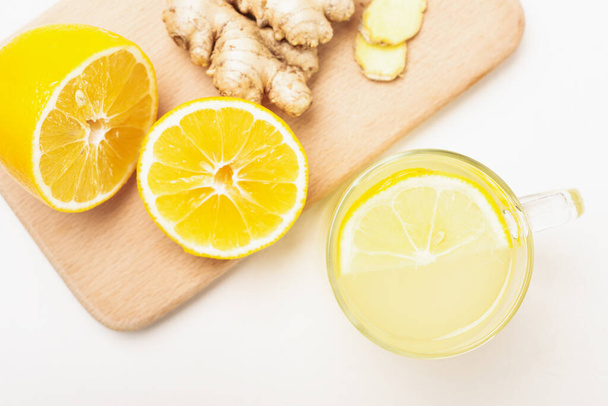 Top view cup of lemon ginger lemonade and ingredients on cutting board. - Фото, изображение