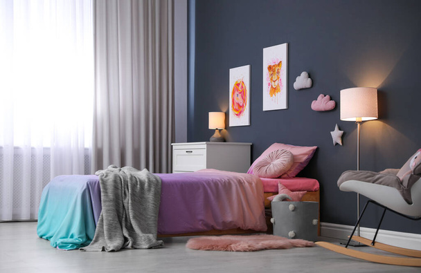 Bed with beautiful linens in children's room. Modern interior design - 写真・画像