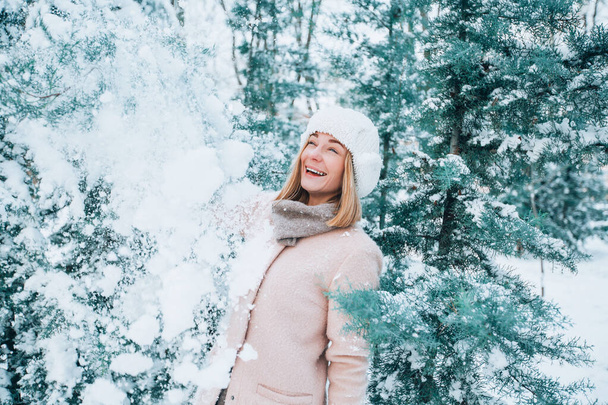 Nuori onnellinen tyttö nauraa kävely keskuudessa lumiset puut - Valokuva, kuva