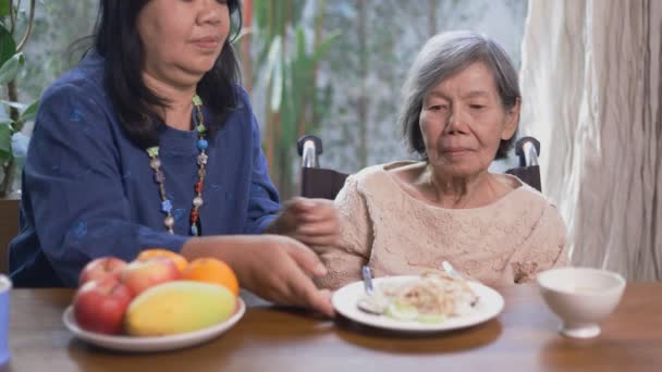 Senior aziatische vrouw verveeld met voedsel. - Video