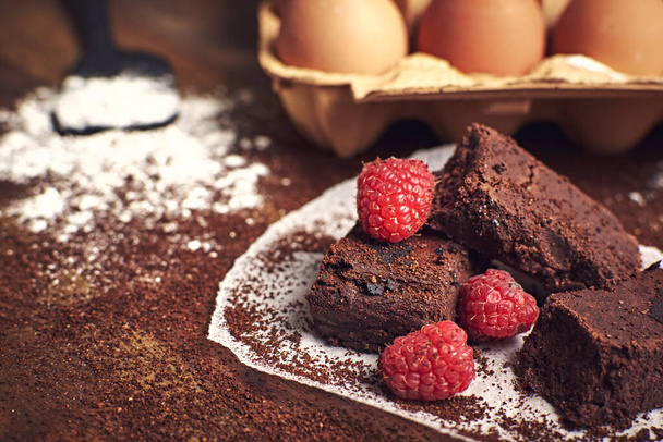 A selective focus shot of eggs and homemade chocolate brownie dessert with raspberries - Fotoğraf, Görsel