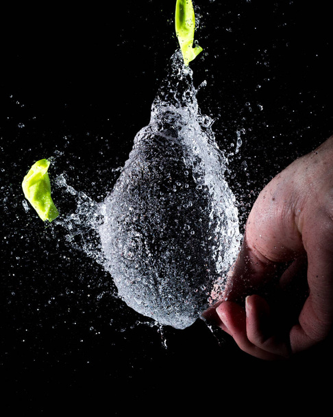 A closeup shot of a popped balloon full of water - Foto, Imagem