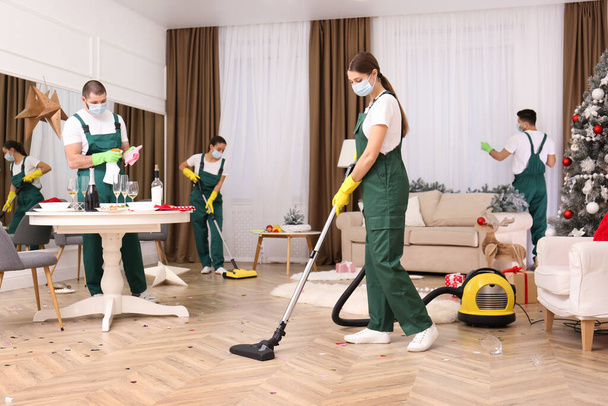 Cleaning service team working in messy room after New Year party - Foto, Imagem