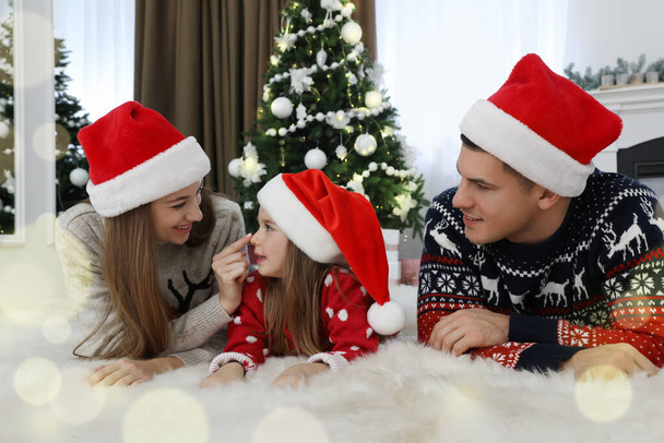 Happy family in Christmas hats at home - Фото, зображення