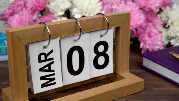 Pöytäkalenteri, jossa on maaliskuun 8. päivä ja kukkakimppu. Herkkä krysanteemit kansainvälisen naistenpäivän - Materiaali, video