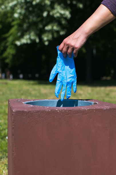 disposal of latex glove in park garbage bin - Fotoğraf, Görsel
