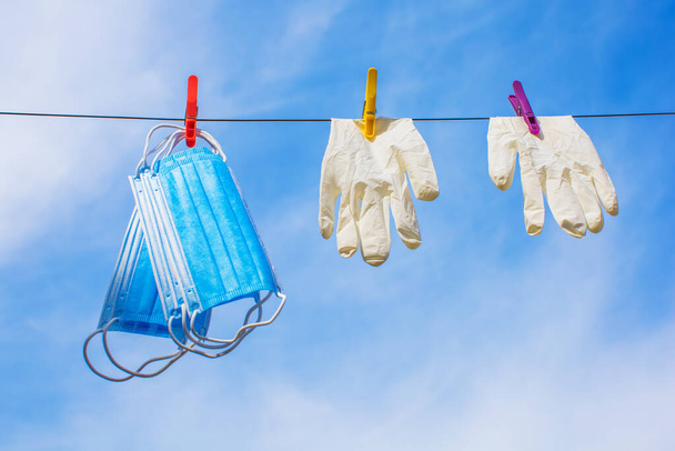surgical face masks and protective gloves dried on sunlight after washing and disinfection - Foto, Imagen