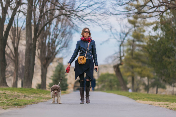 young woman taking her dog for a walk - Photo, image