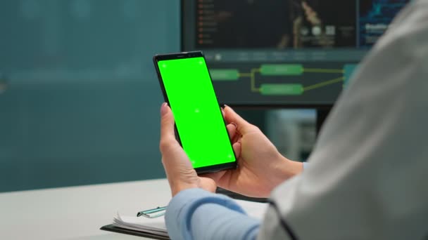 Medico in laboratorio scientifico in possesso di telefono con schermo verde - Filmati, video