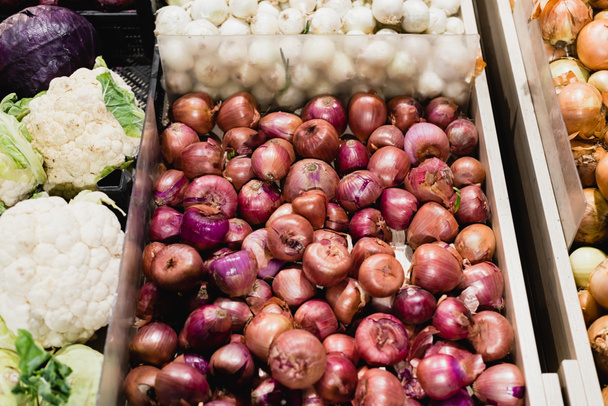 Vista ad alto angolo di cipolle e cavolfiori nel supermercato  - Foto, immagini