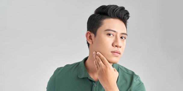 Portrait of Handsome young asian man on white background. Concept of men's health and beauty, self-care, body and skin care - Photo, image