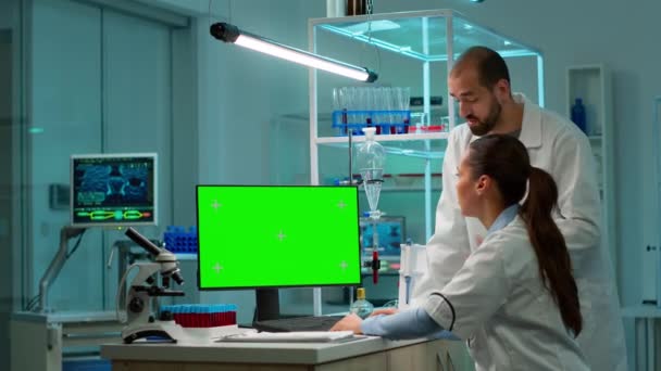 Forscher unterhält sich mit Mann beim Tippen auf grünem Bildschirm - Filmmaterial, Video
