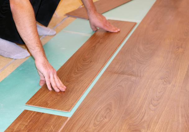 Worker installing new laminate flooring - Photo, Image