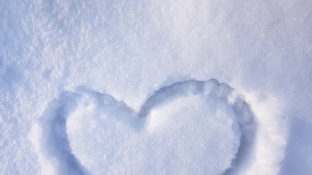 Video 4K, un cuore disegnato sulla neve nel parco. San Valentino, vacanza invernale in città, macchina fotografica al rallentatore - Filmati, video