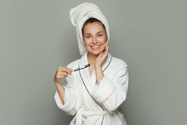 Happy spa woman with cute smile, white teeth, toothbrush and toothpaste on white - Foto, Imagem