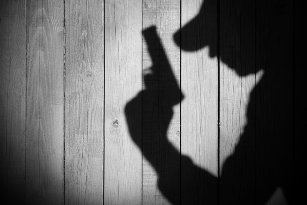 silhouet van de gangster of onderzoeker of spion op natuurlijke houten wal - Foto, afbeelding