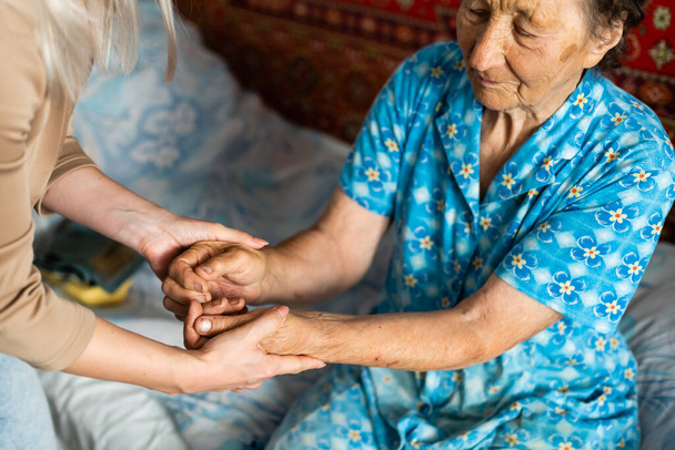 Ηλικιωμένη γυναίκα με τον φροντιστή της στο σπίτι - Φωτογραφία, εικόνα