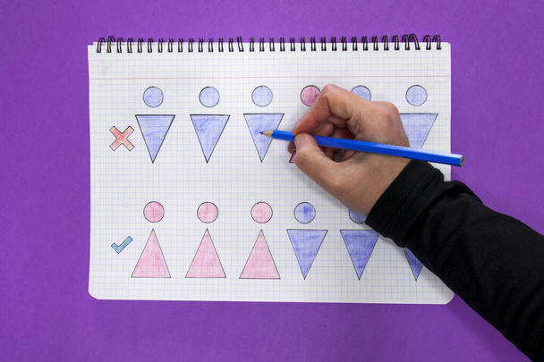Foto aerea di un quaderno con disegni che rappresentano disuguaglianza e uguaglianza tra uomini e donne e una mano che li disegna. Concetto di uguaglianza di genere. - Foto, immagini