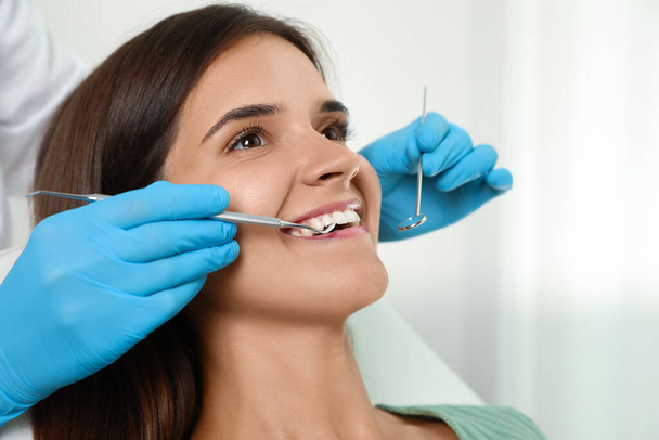 Dentist examining patient's teeth in modern clinic, closeup. Cosmetic dentistry - Foto, afbeelding