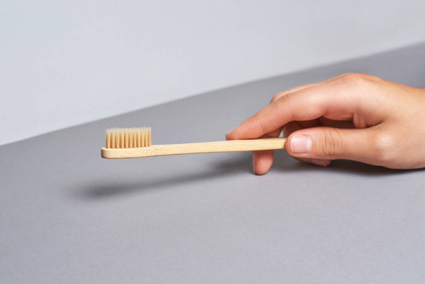 Hand holding toothbrush. Bamboo eco brush - Foto, imagen