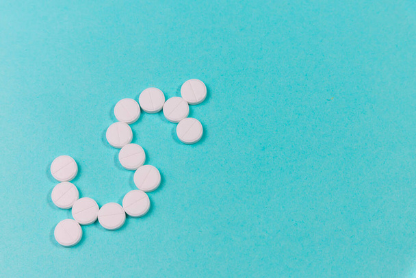 Pills on a blue background in the form of a dollar - Fotoğraf, Görsel