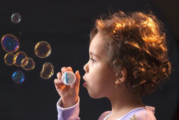 kleines Mädchen spielt mit Seifenblasen - Foto, Bild