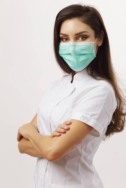 piękna kobieta lekarz składane ramiona noszenie maski - Zdjęcie, obraz